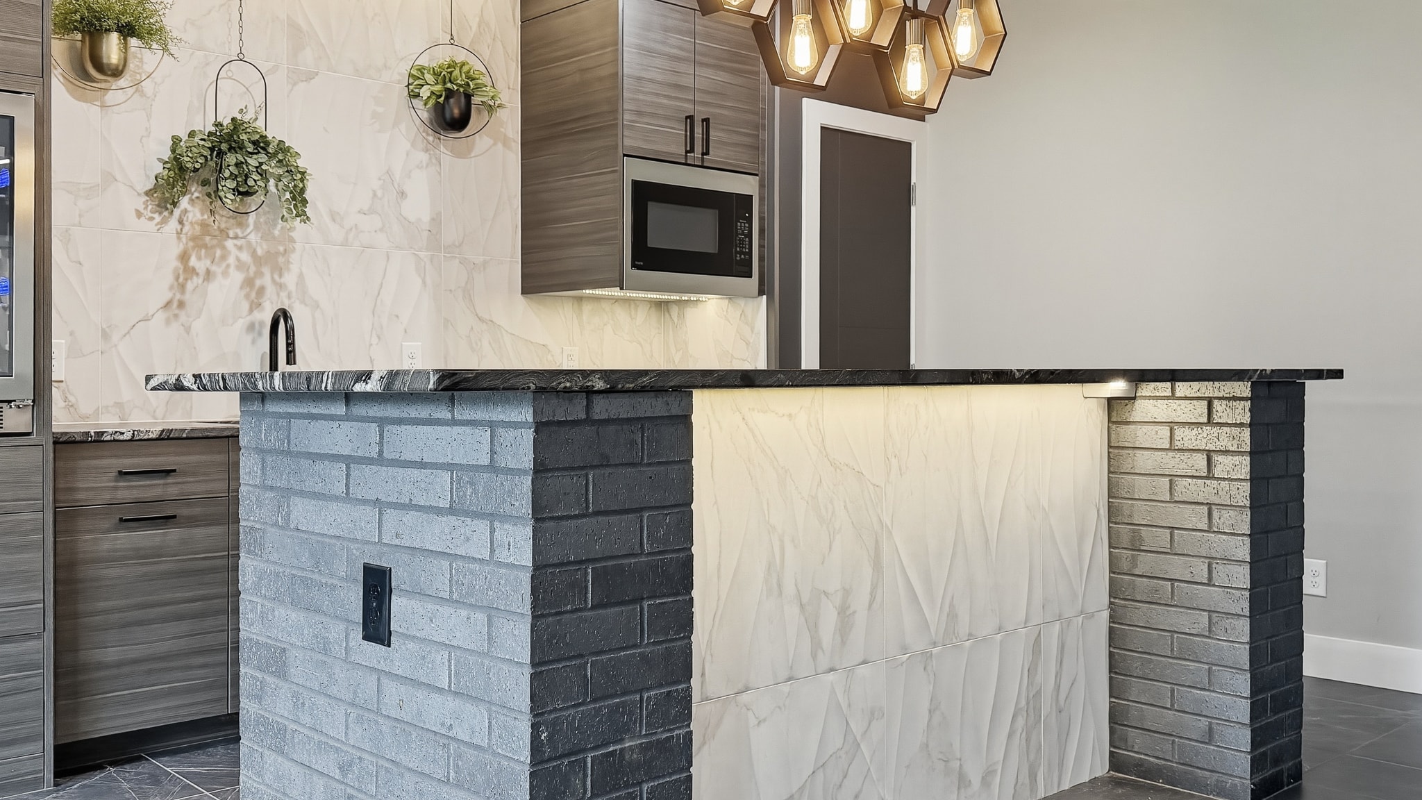 Custom bar with brick tile columns, marble countertop and hexagon pendant lighting