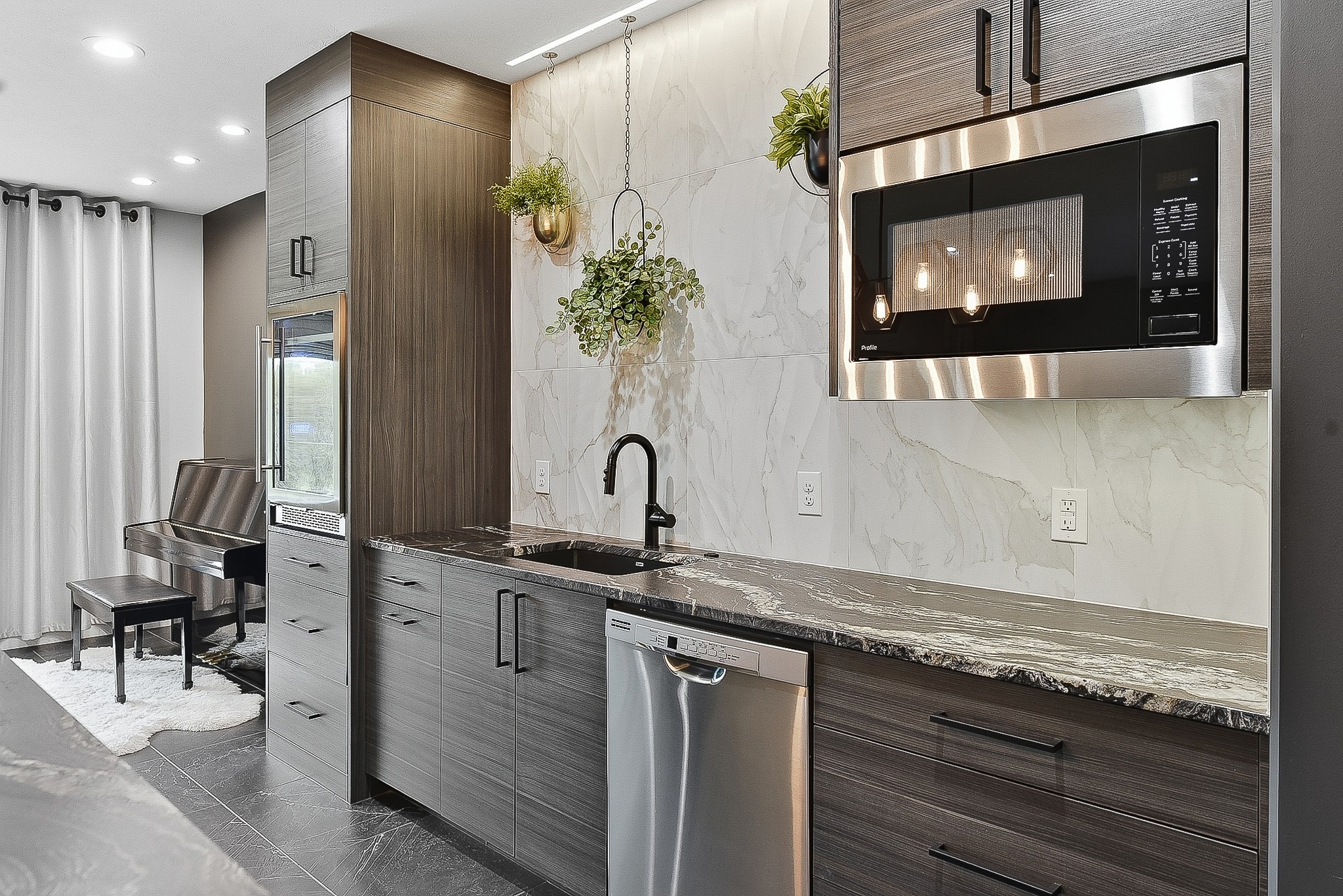 Bar cabinetry with marble tile backsplash, black faucet and stainless appliances