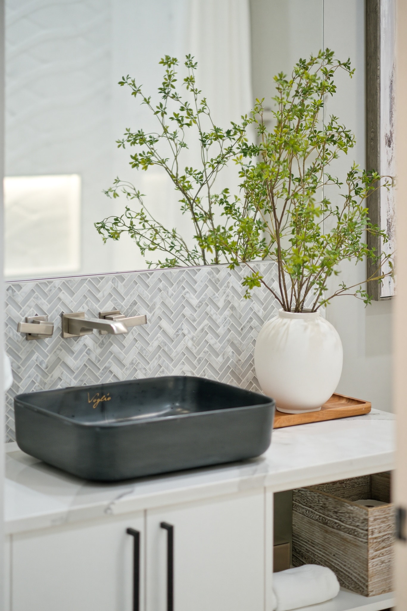 Bathroom vanity with herringbone tile backsplash and vessel sink