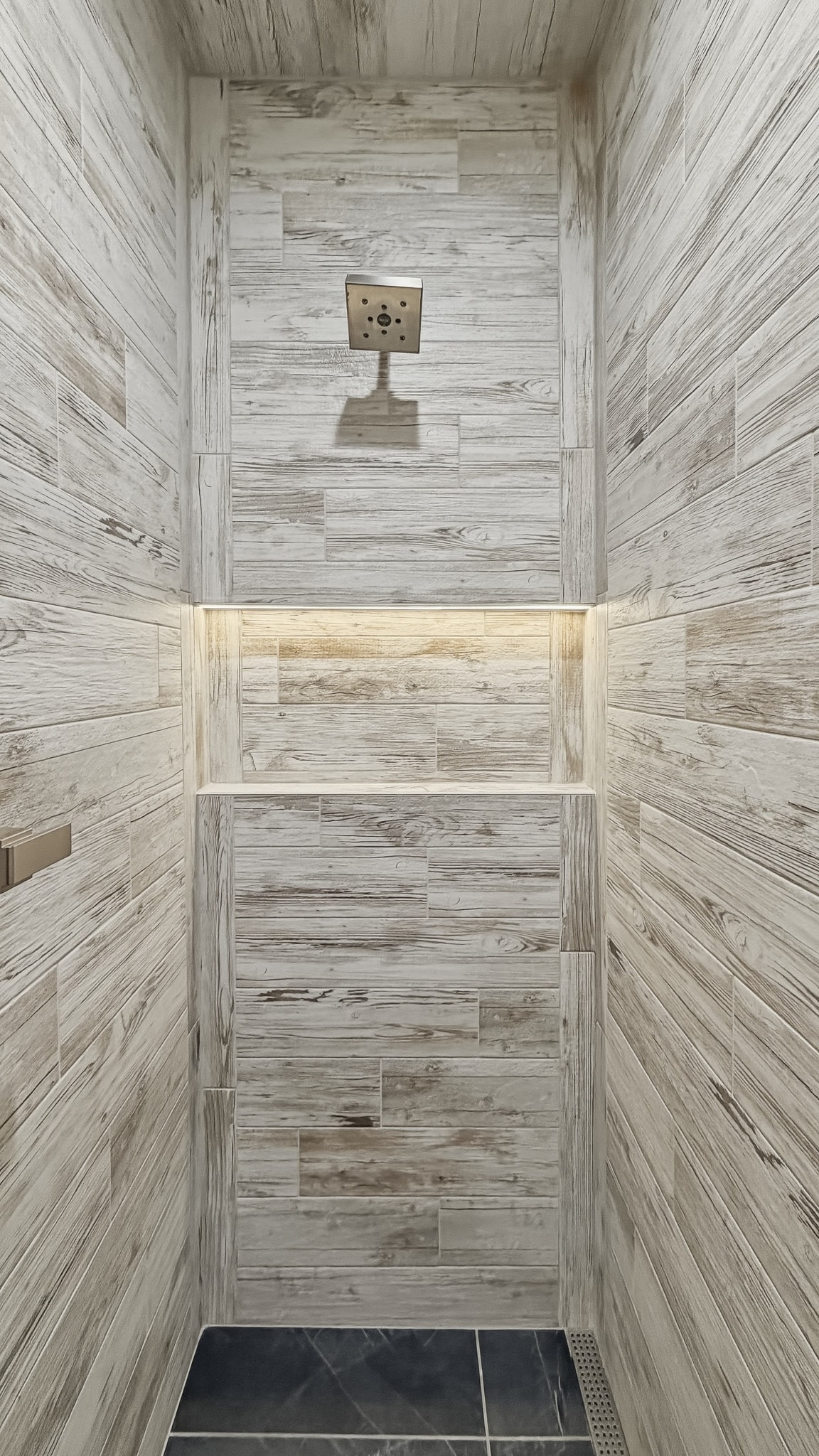 Wood-look tile shower with niche and rain showerhead