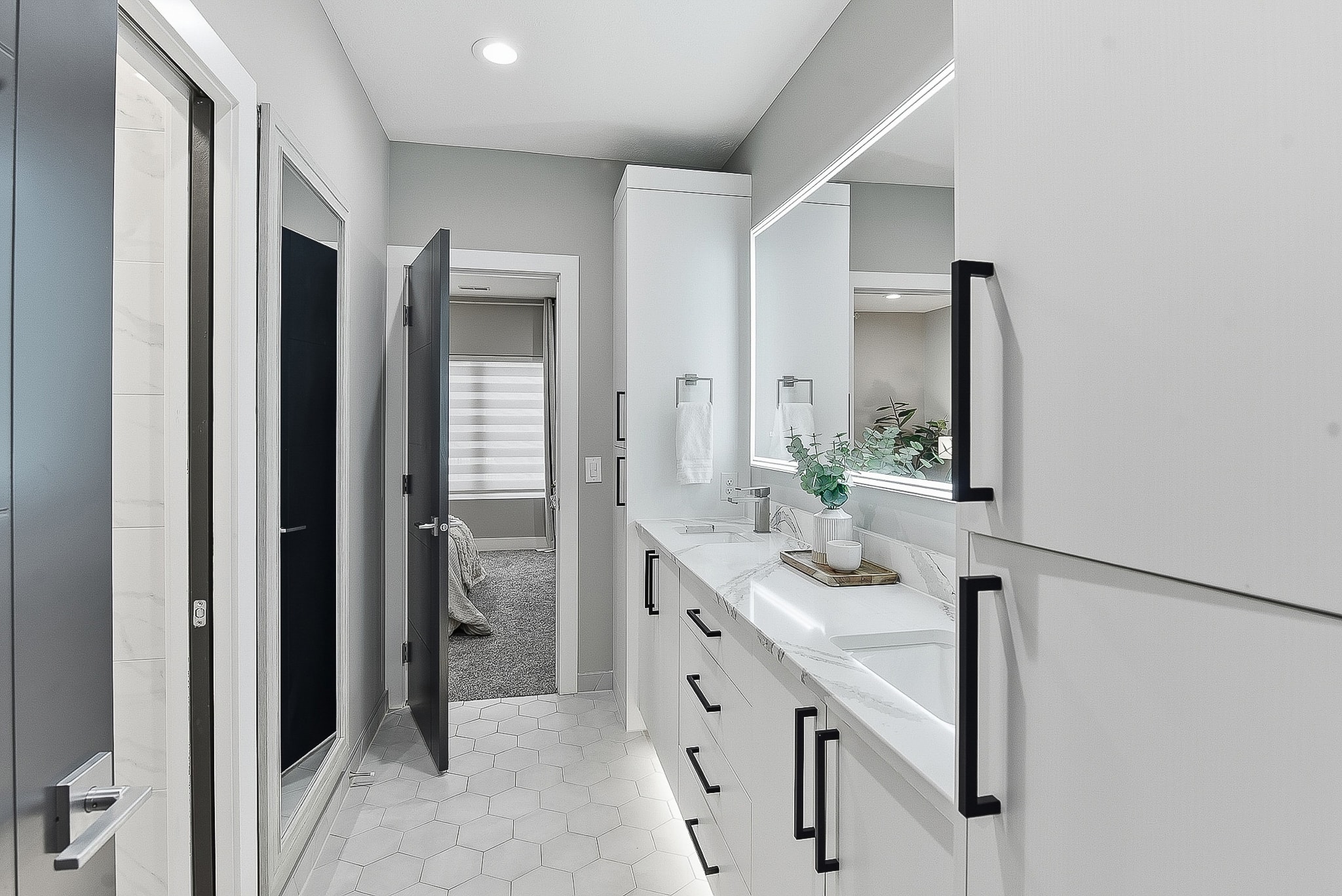 Modern double vanity with hexagon tile floor and LED mirrors