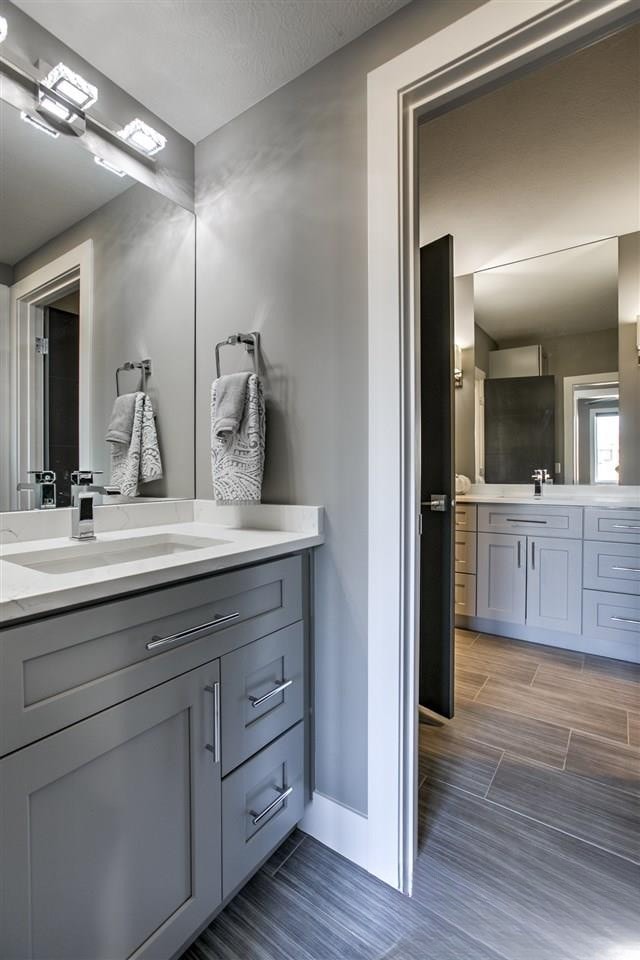Gray shaker vanity with chrome fixtures and wood-look tile floor