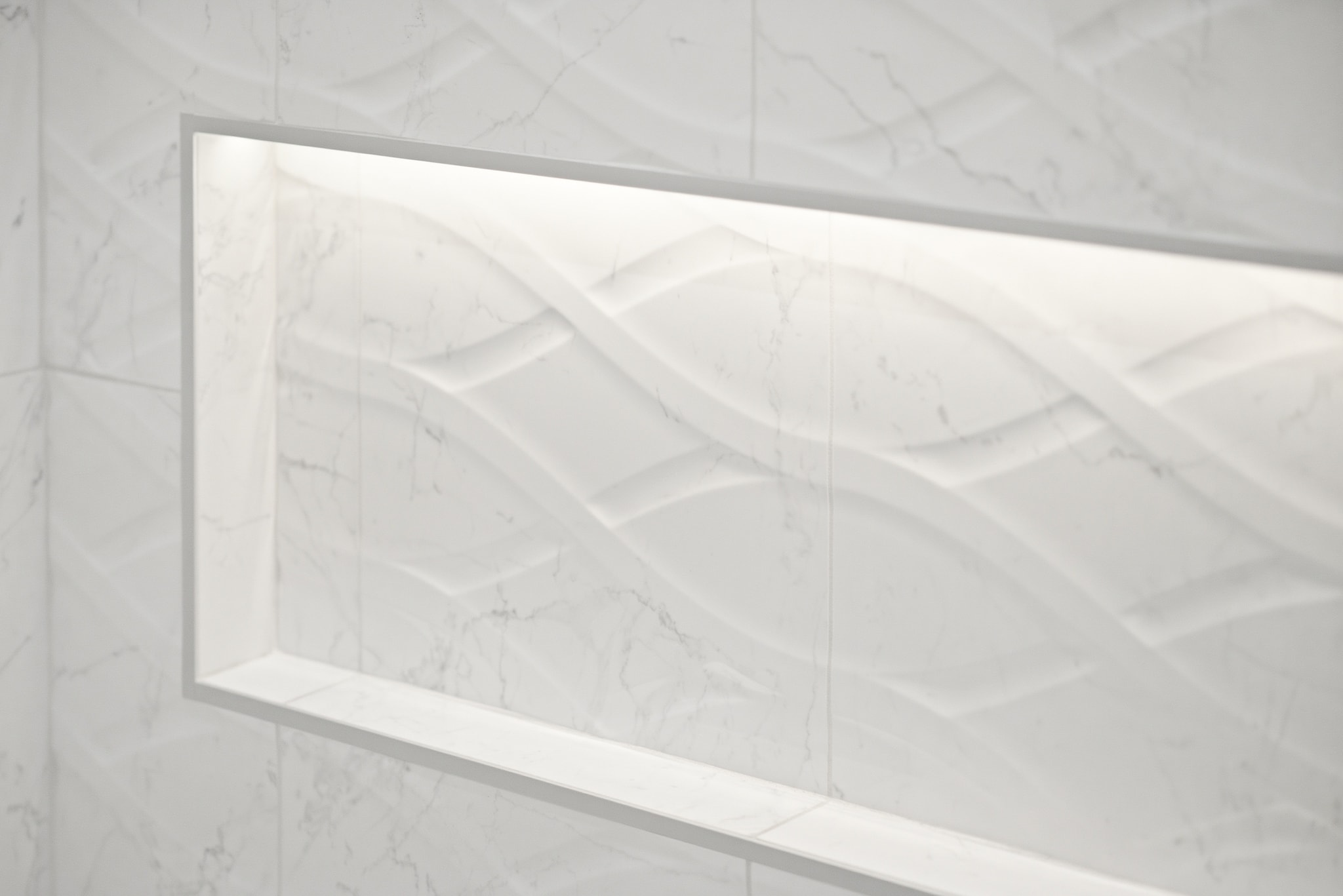 Marble tile shower wall with illuminated niche
