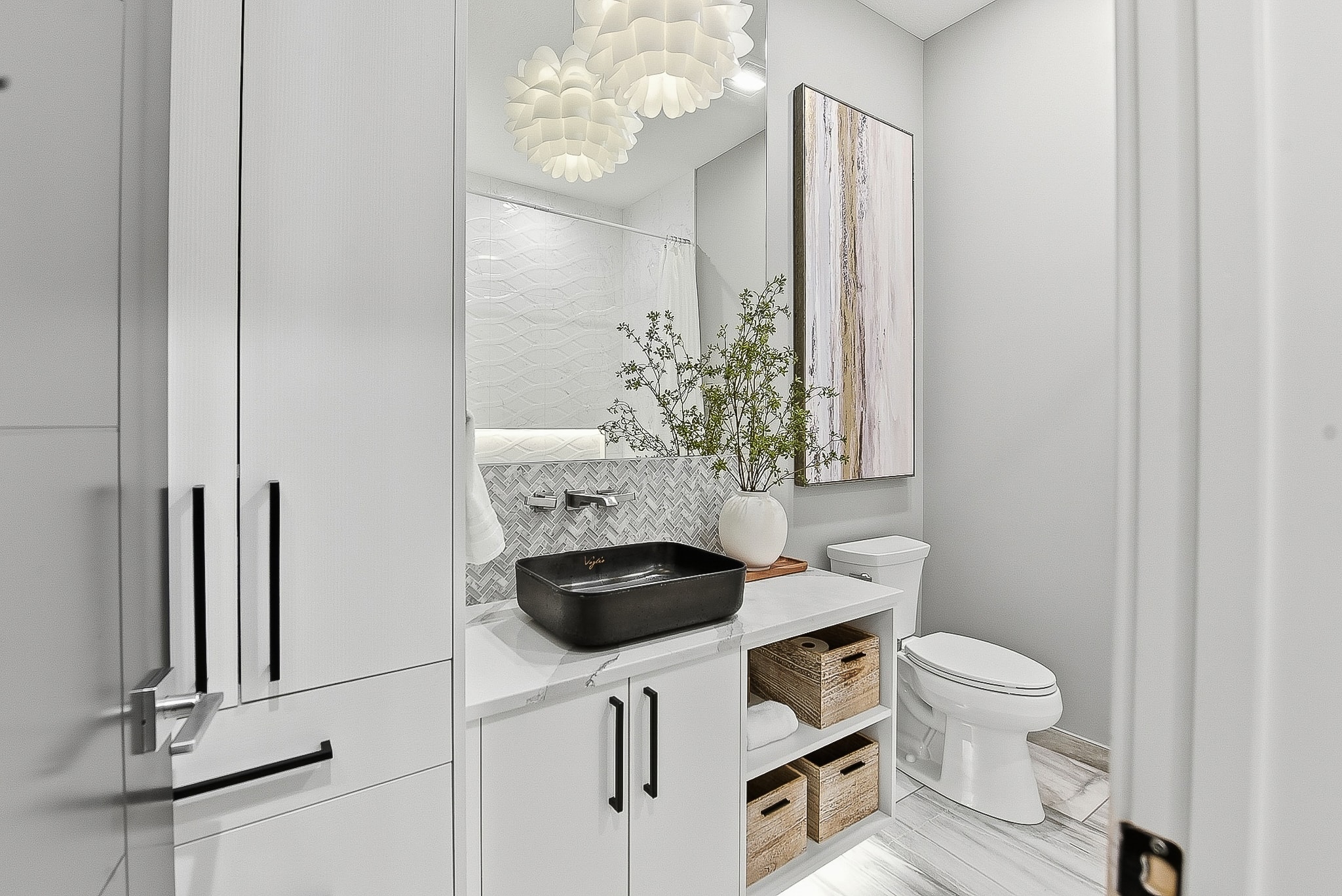 Full bathroom with vessel sink, herringbone tile and floral chandelier