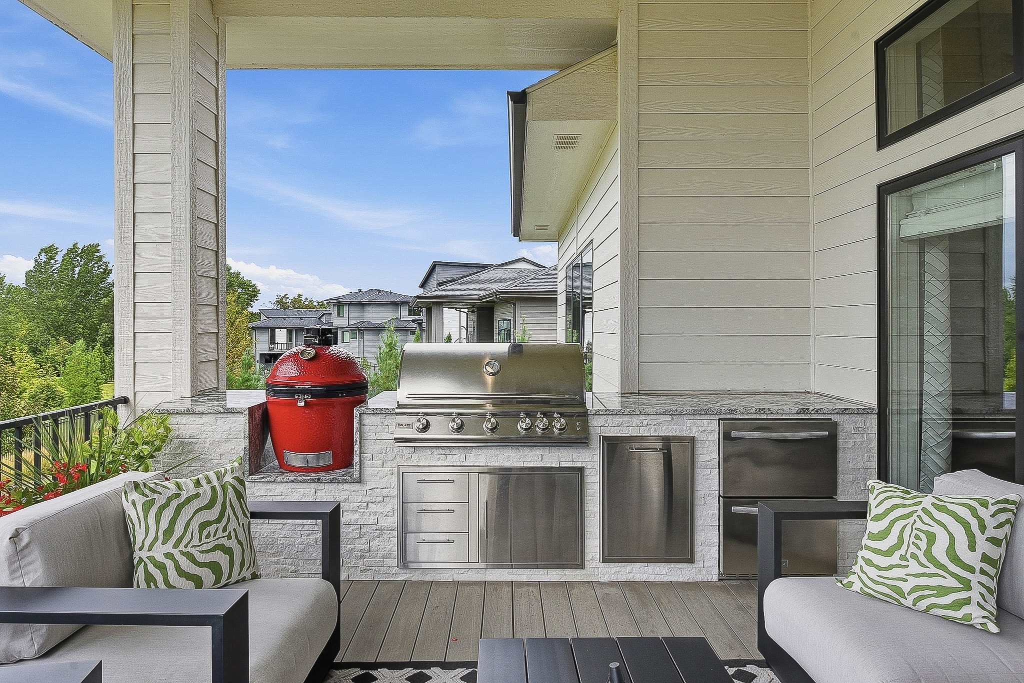 Covered deck with outdoor kitchen, red ceramic grill, stainless appliances and patio seating