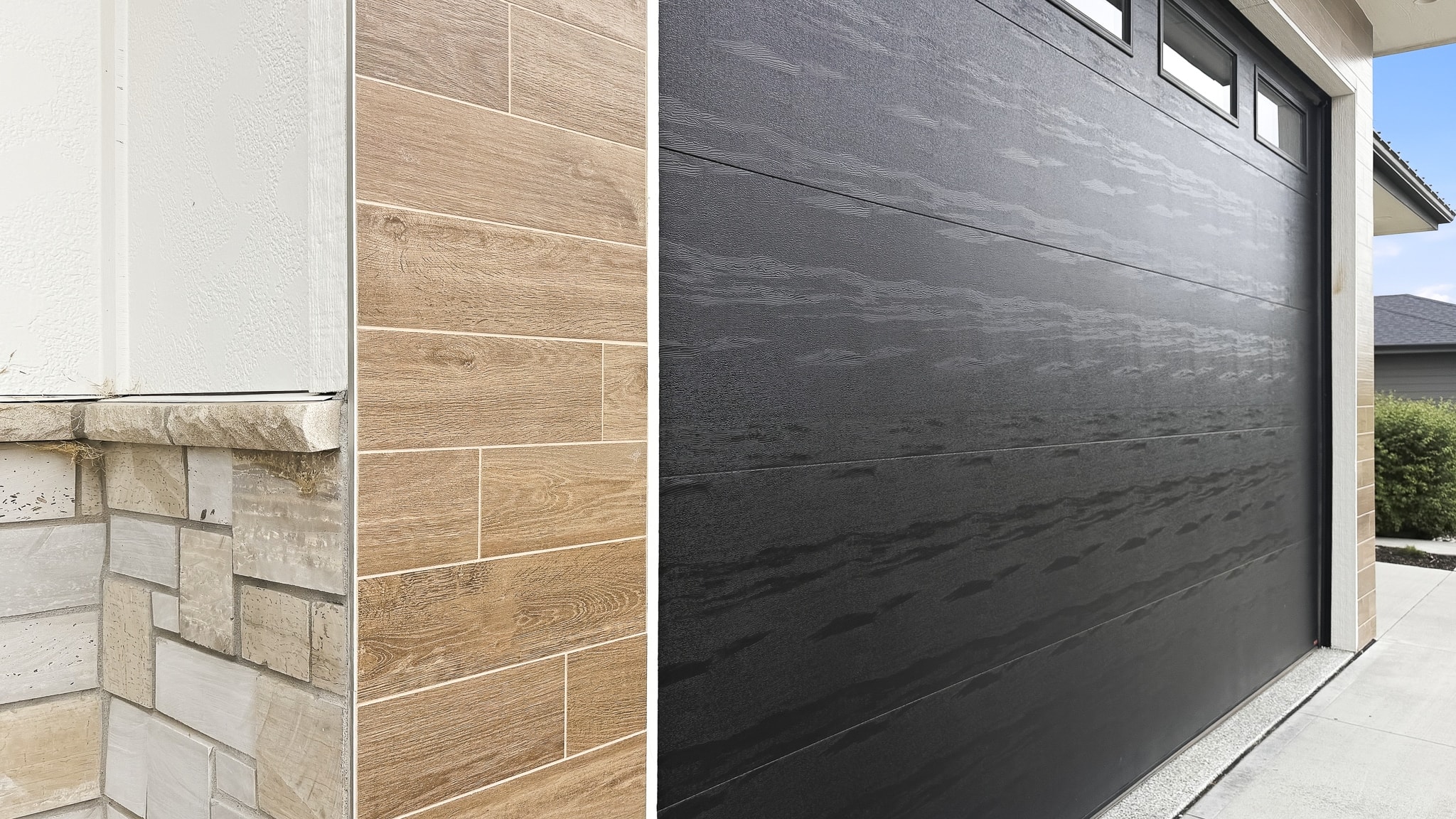 Wood look tile on house exterior wall beside stone foundation and dark garage door