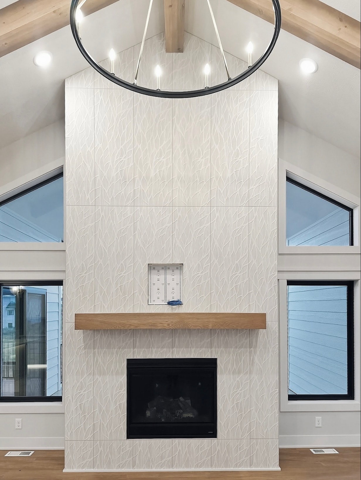 Modern fireplace with white tile surround and circular pendant light
