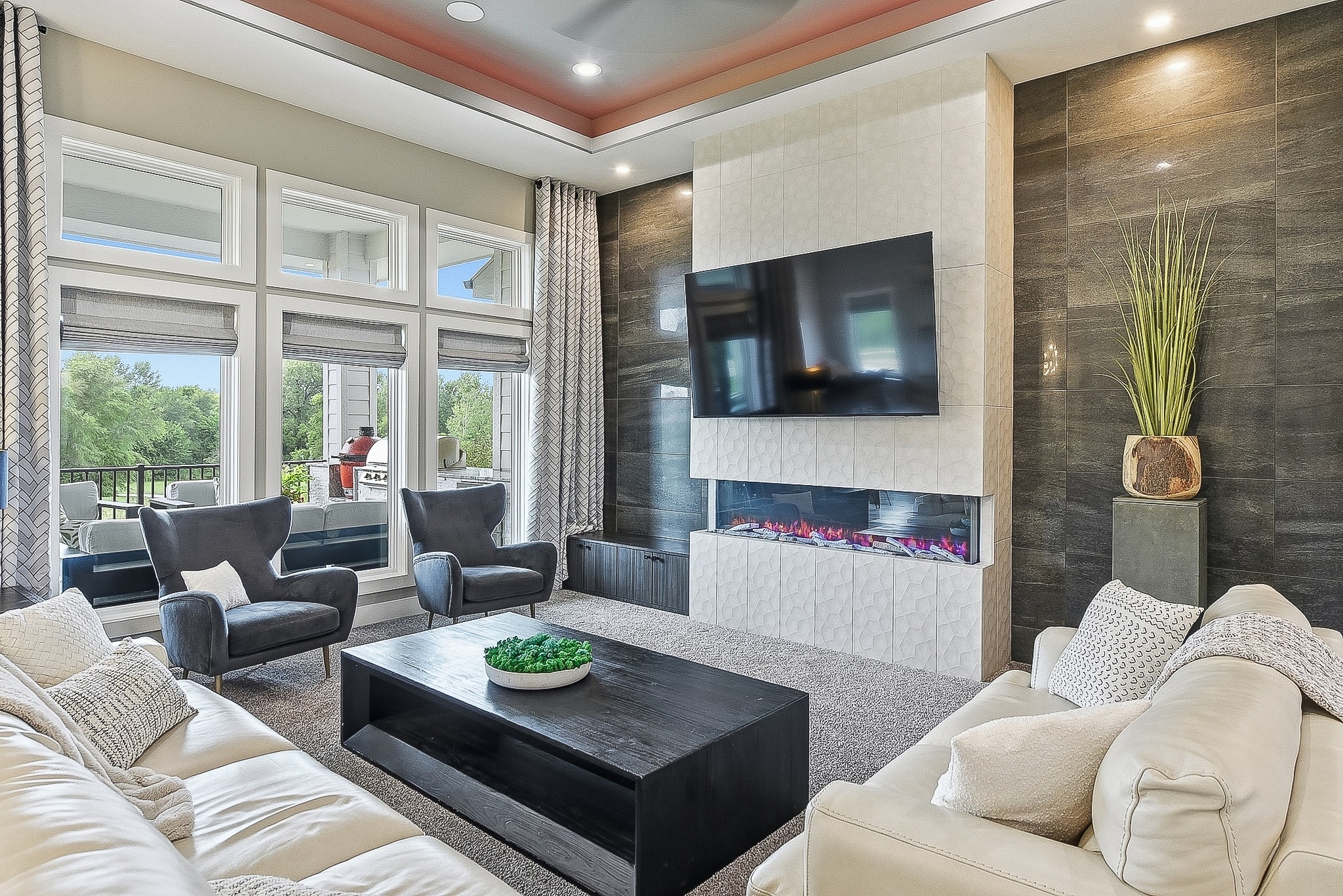 Living room with white geometric tile fireplace, TV mount and dark accent wall