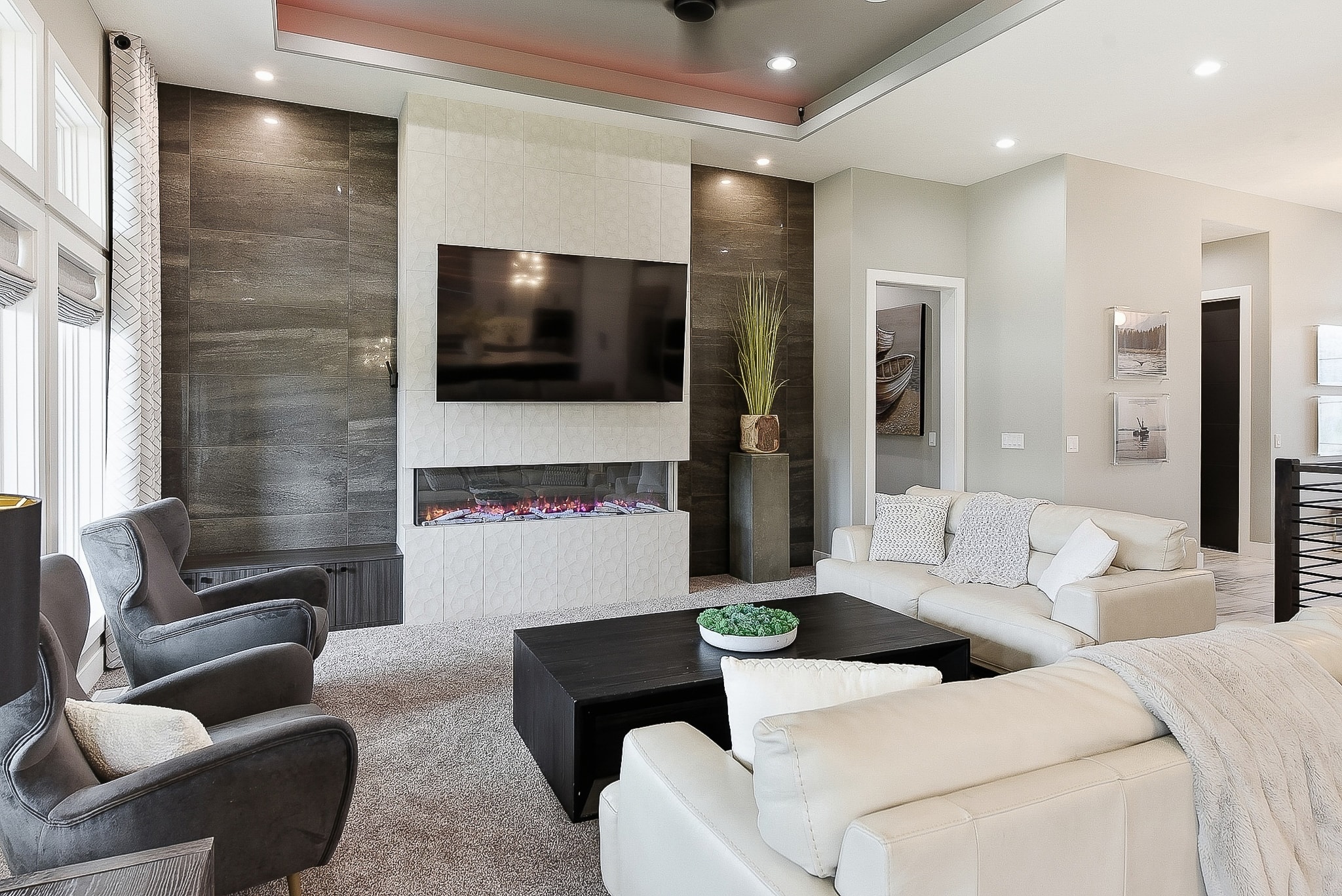 Spacious living room with white tile fireplace feature wall and tray ceiling