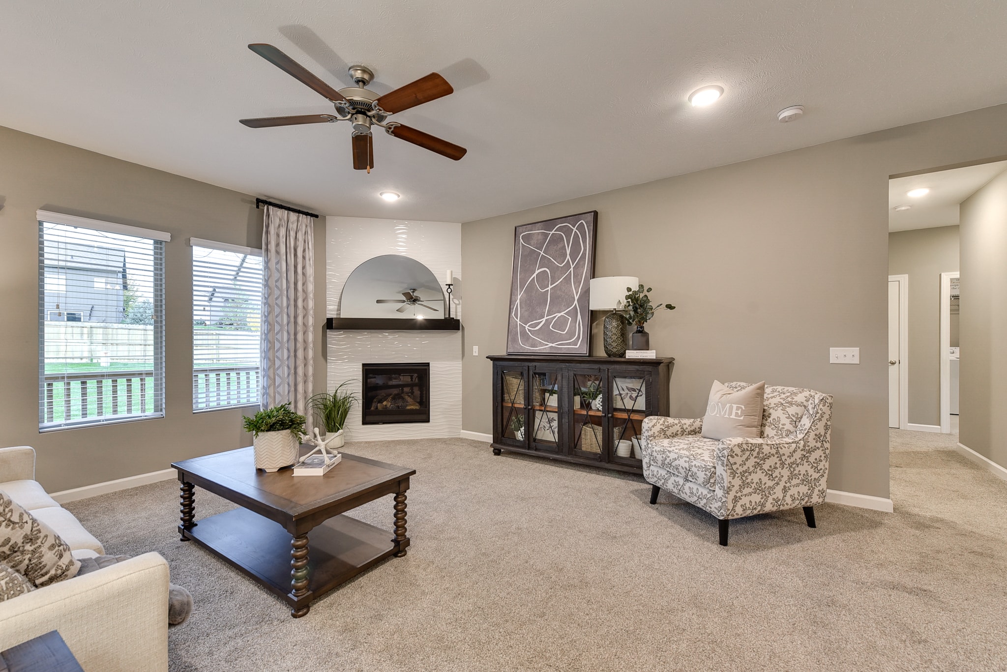 Corner fireplace with white wave tile surround and dark wood mantel