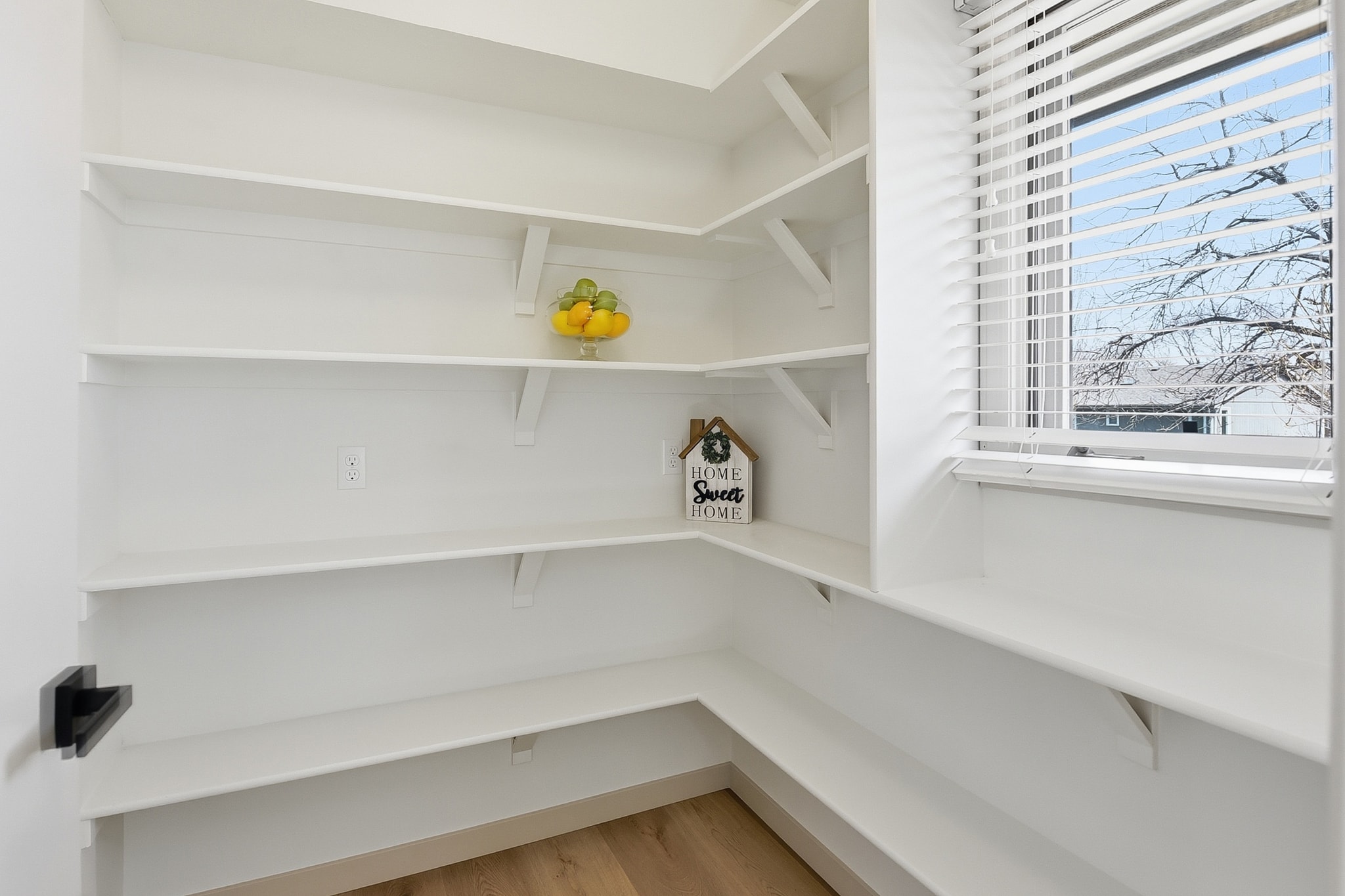 Walk-in pantry with white shelving and LVP flooring