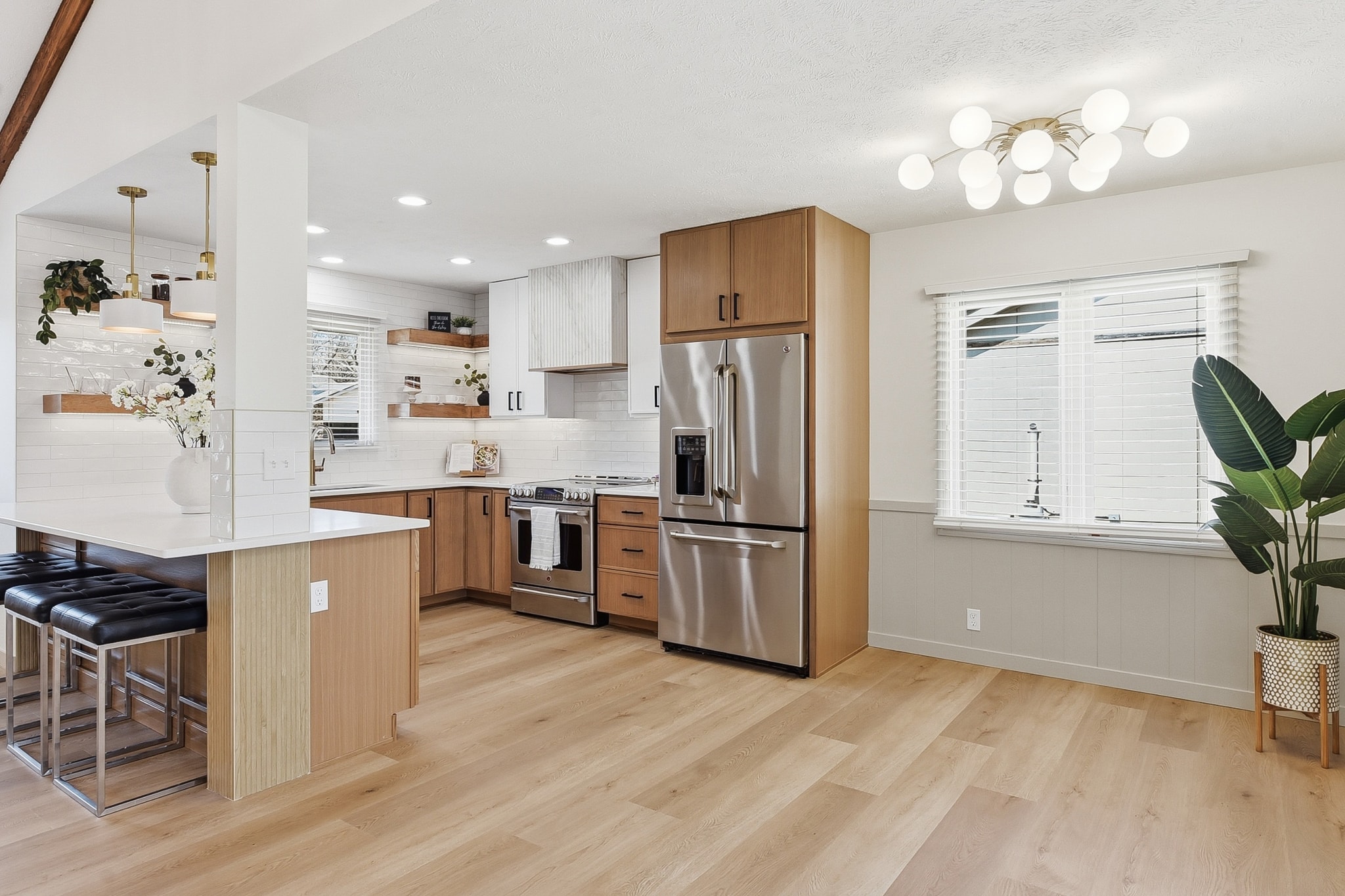 Modern kitchen with LVP flooring, wood cabinetry and stainless appliances